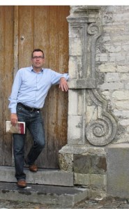 Ward Caes met boek Max Deauville aan kerk Wakkerzeel (foto Conny Justé)